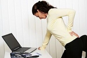 A woman has back pain in her lumbar region